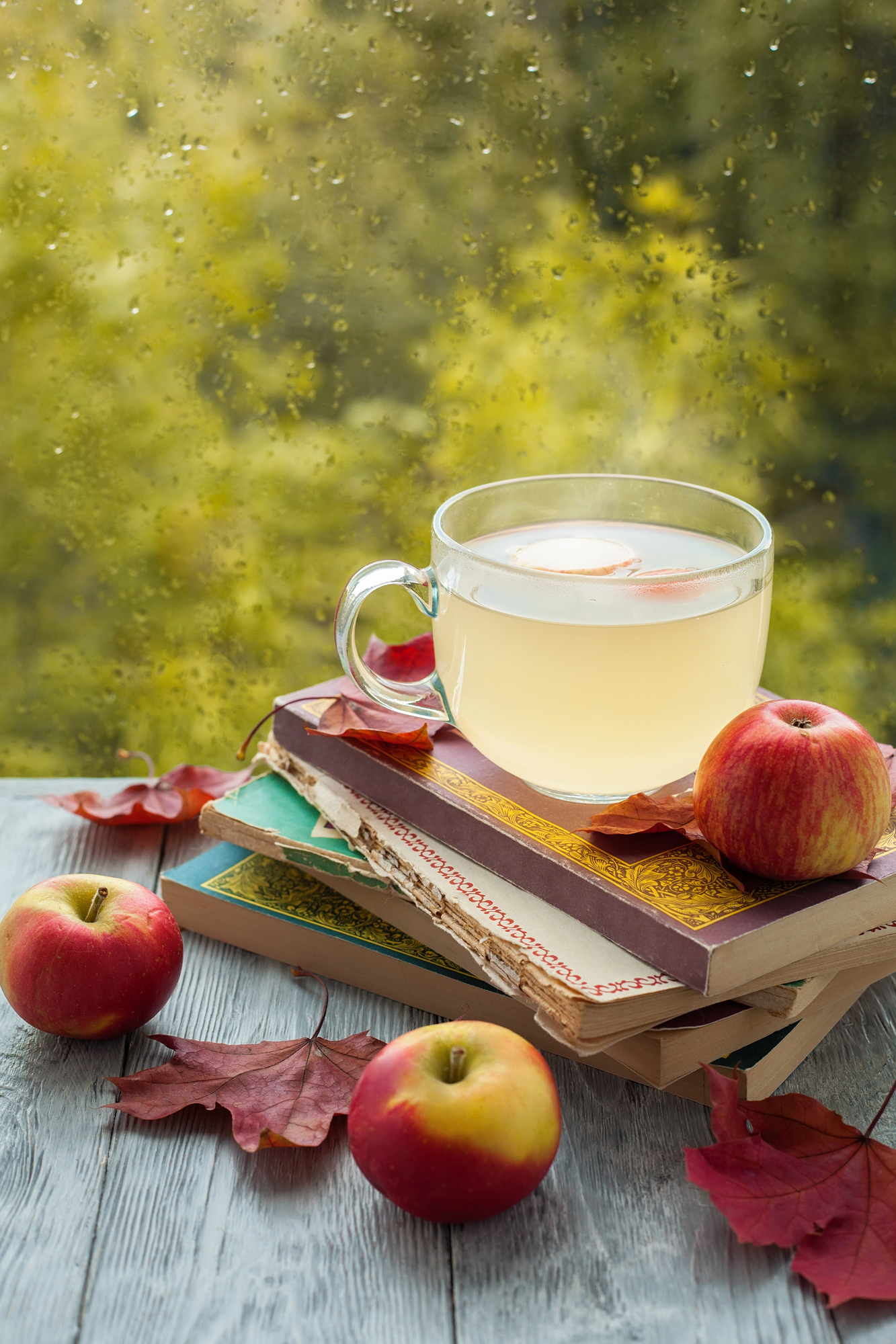 cider and books on table with some apples