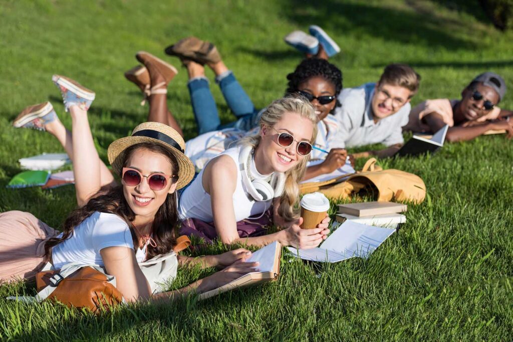 young adults outside with books